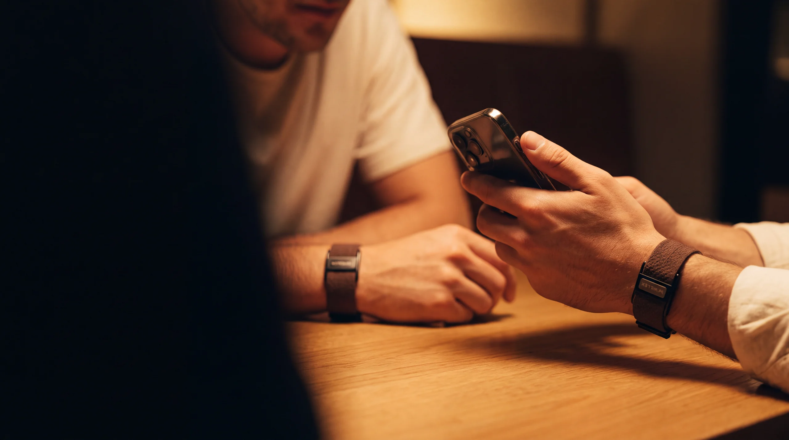 Two people talking, one showing a phone